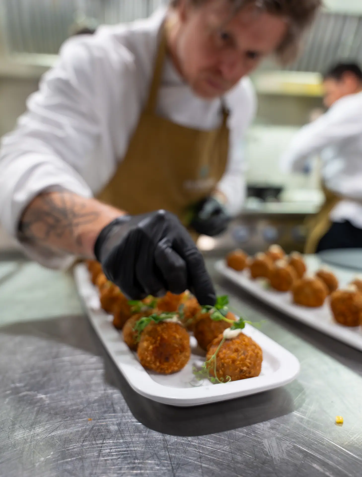 Chef presenting freshly plated gourmet croquettes